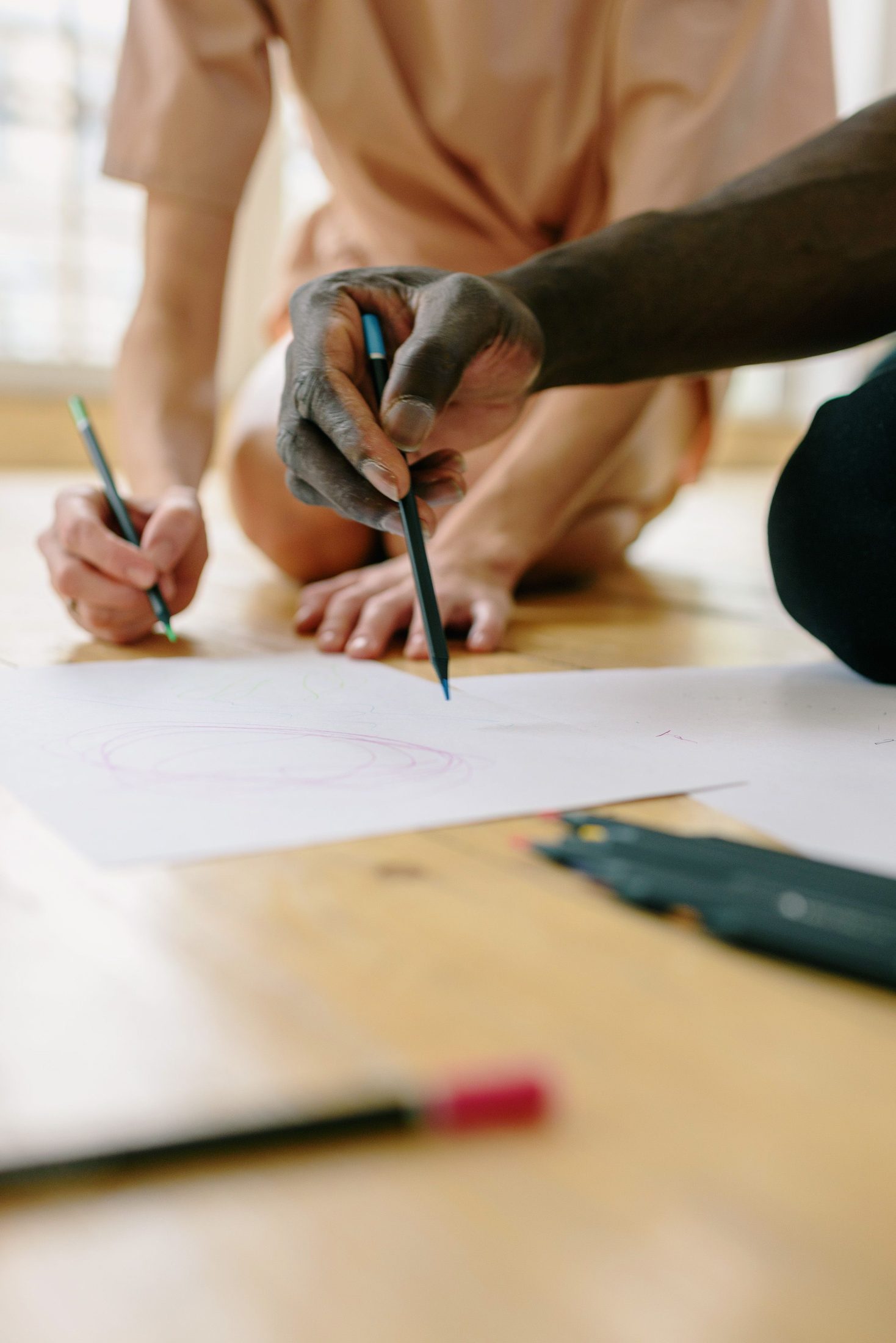 Two people sketching a plan on paper.