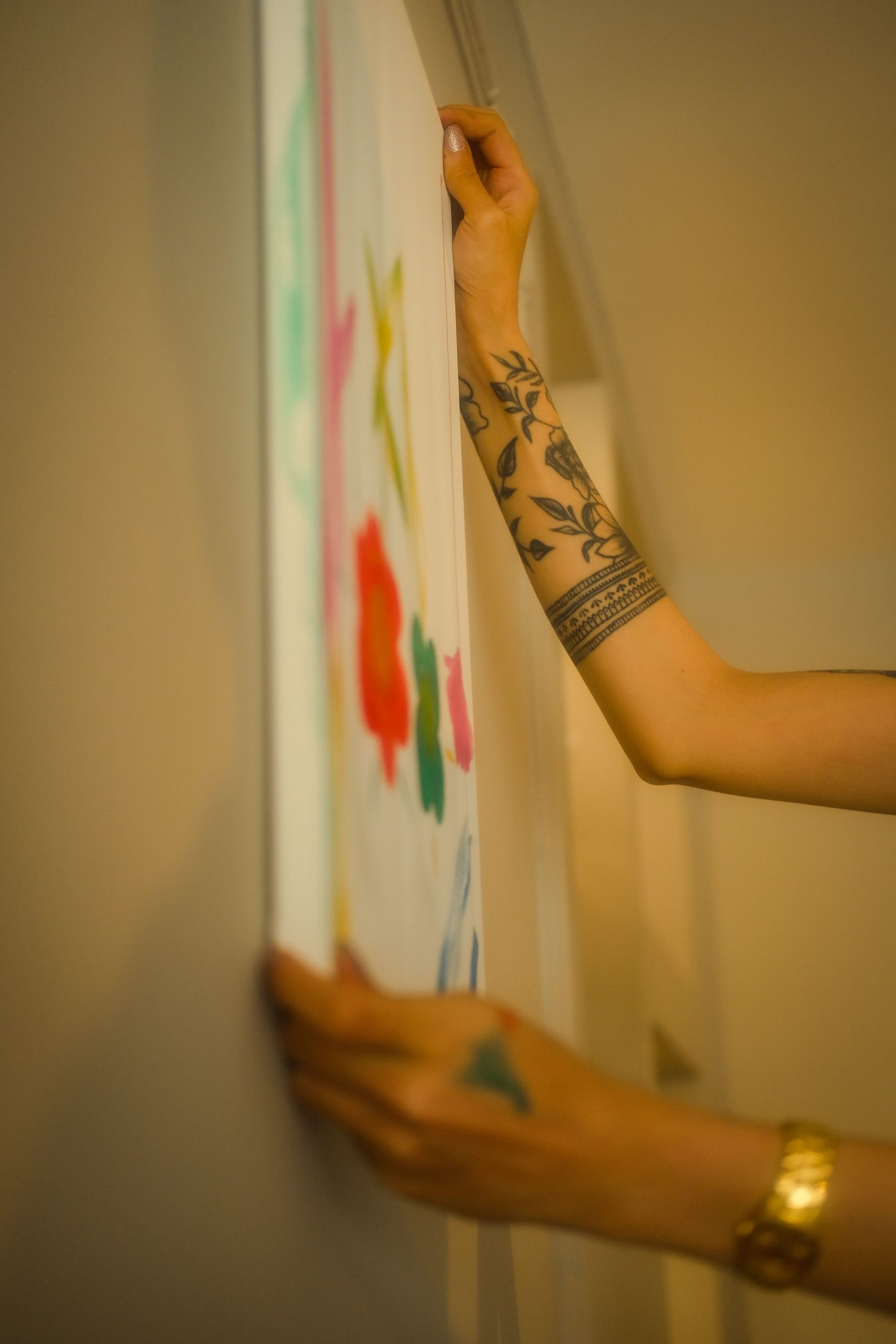 A hand painting a mark onto a canvas.
